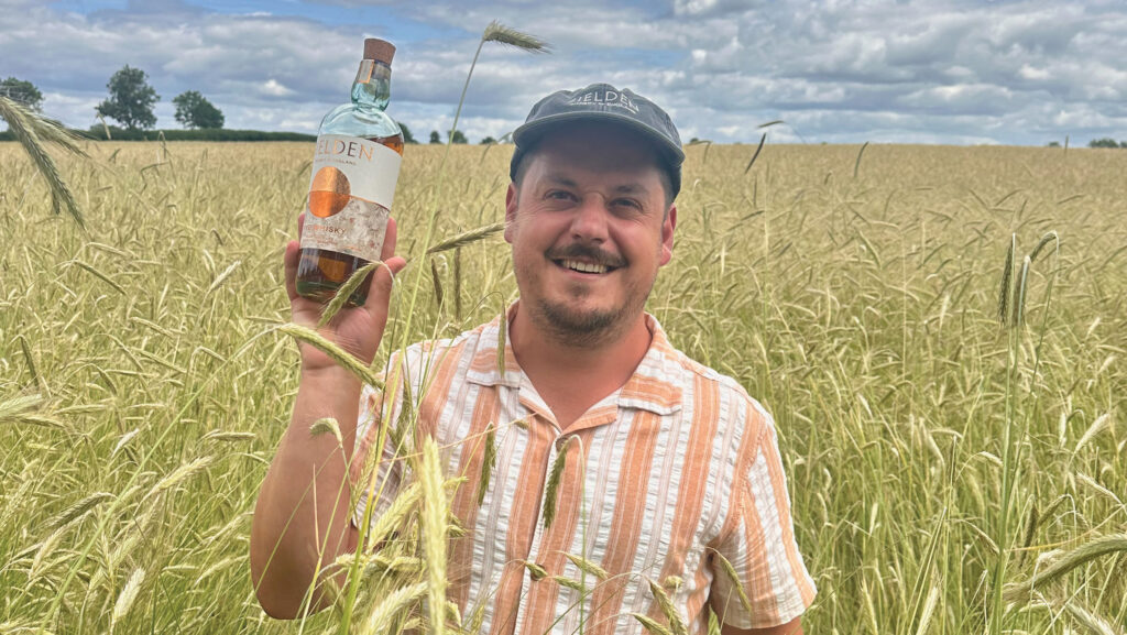 Chico Rosa holding bottle in rye crop
