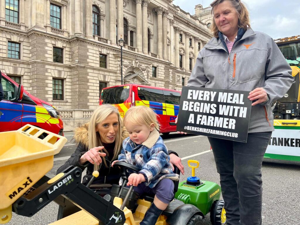 DUP agriculture spokesman Carla Lockhart (left), child in toy tractor, and Newbury farmer and Berkshire Farmers spokesman Caroline Graham
