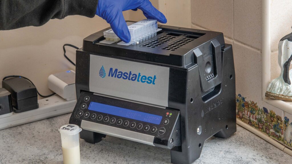 Gloved hands operating a testing machine