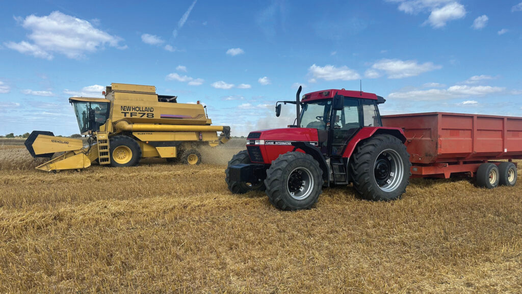 Combine and a tractor in a harvested field