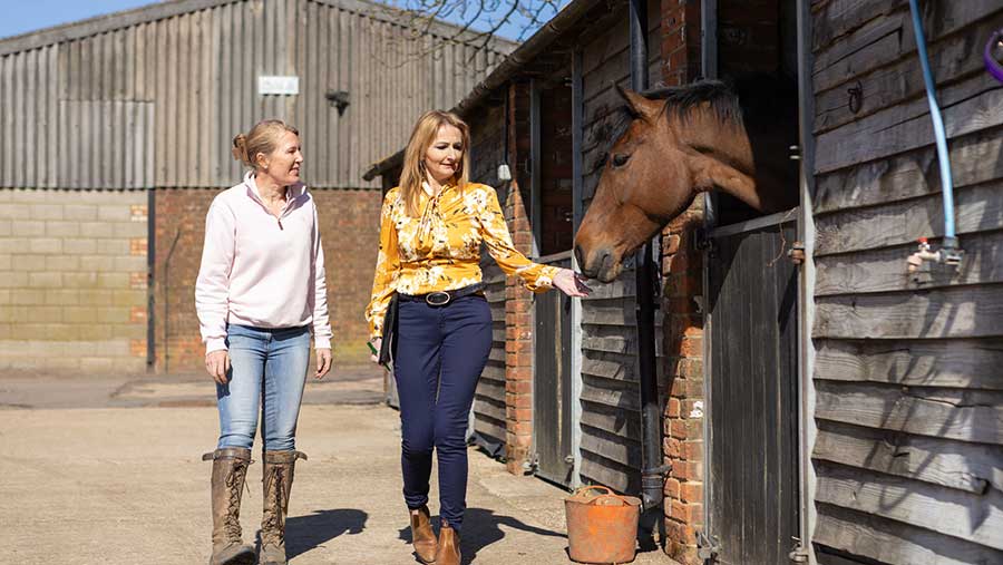 NFU agent pictured next to horse in stable