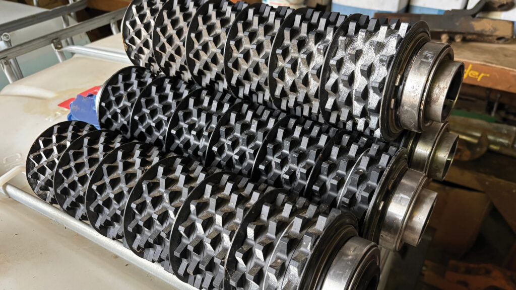 Spiked rollers inside spreader