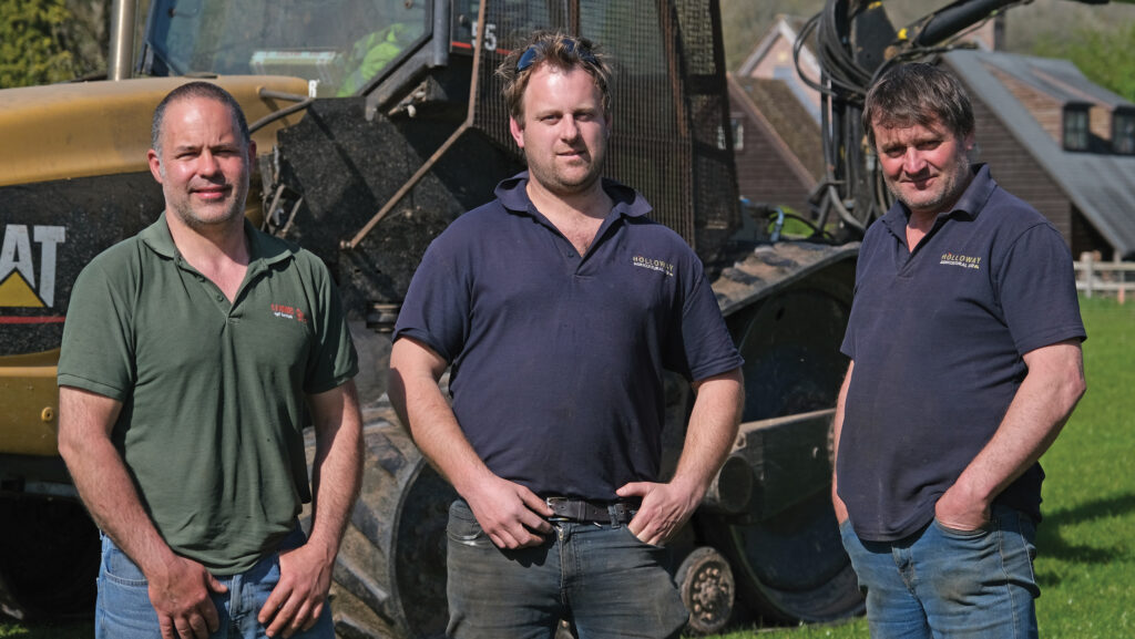 Three men in front of a tractor