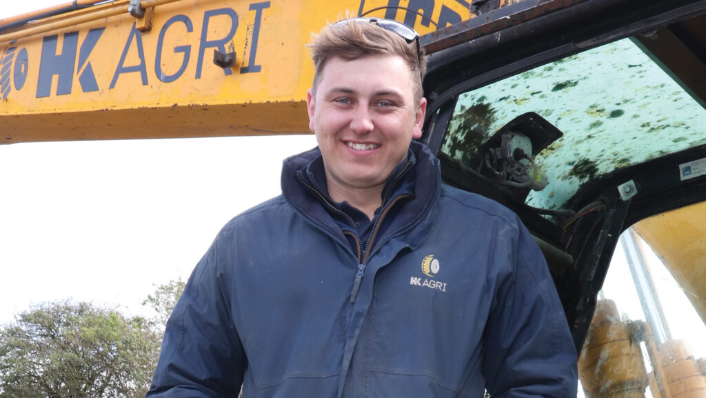 Man smiling beside a digger