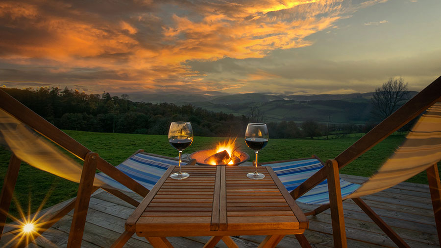 Two wine glasses on table overlooking rural view