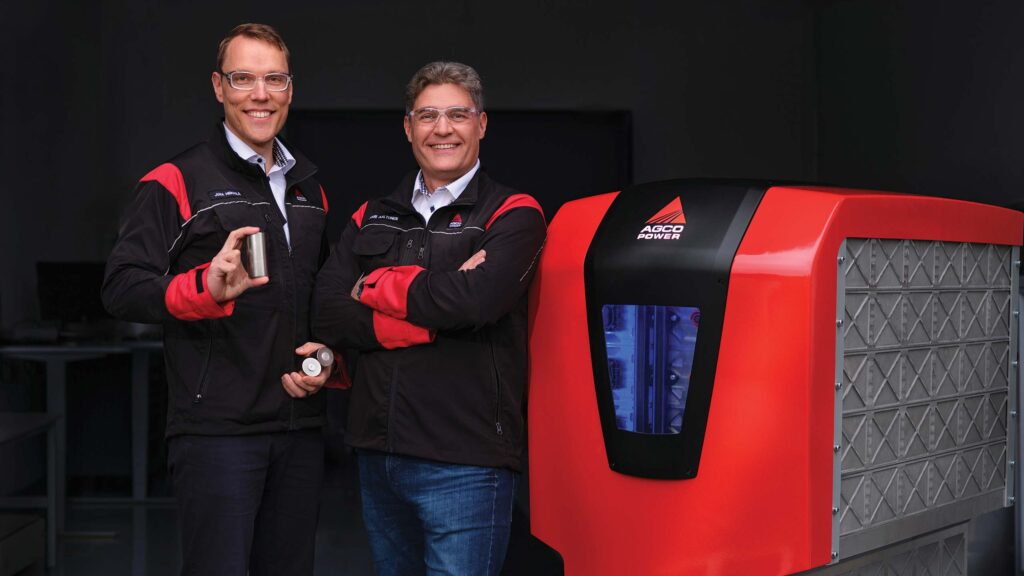 Two men beside a large battery pack