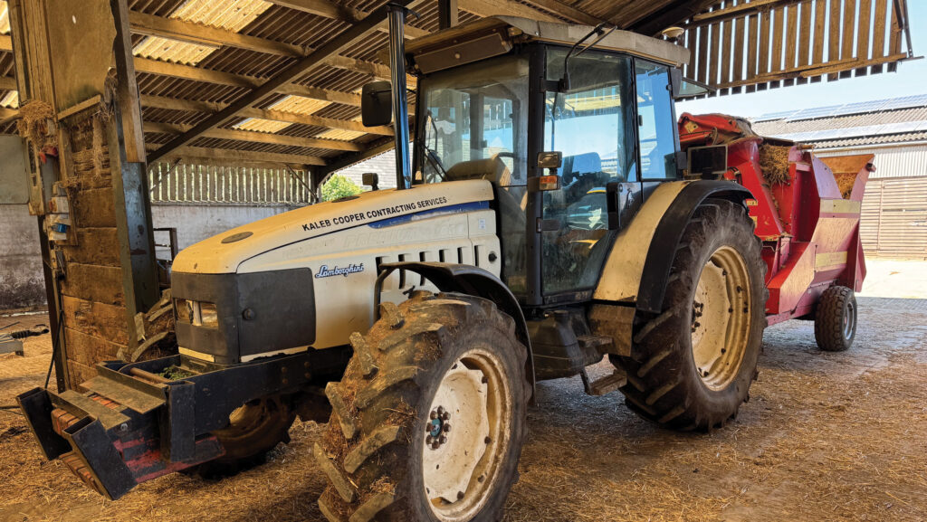 Tractor in a shed with straw blower attached