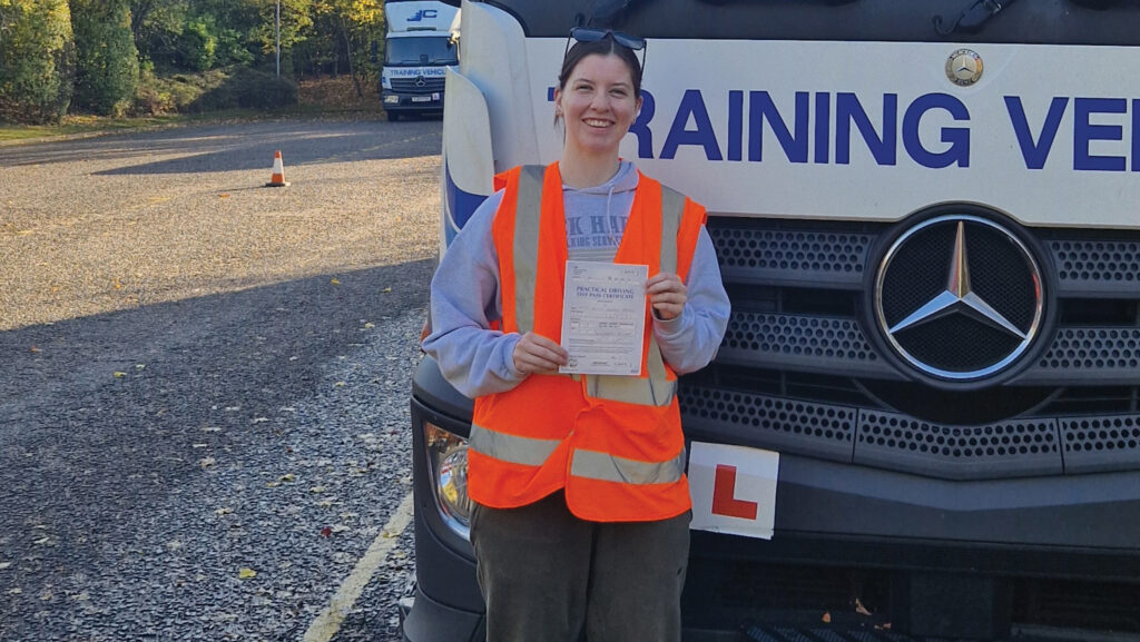 A woman standing in front of an HGV