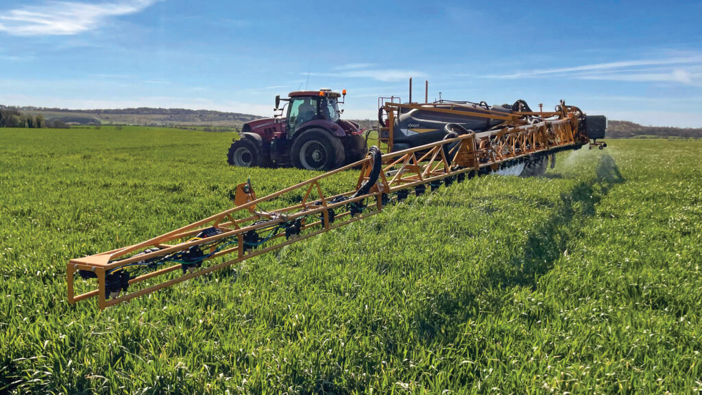 Sprayer in a field with boom extended