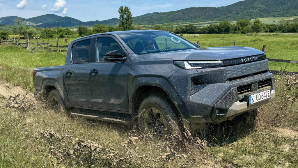 Electric pickup driving through a ditch