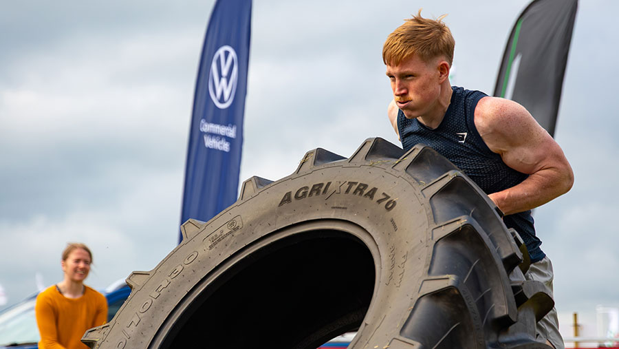 Farmer lifting large tyre