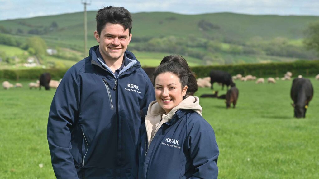 Josh and Harriet Millichap standing in field with livestock
