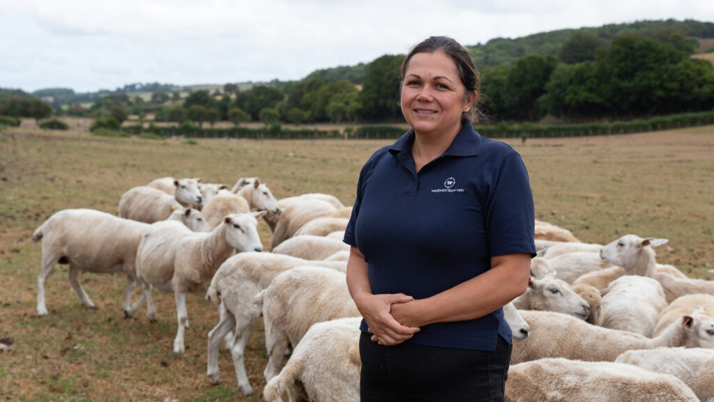 Sharminda Lockwood in a field with sheep