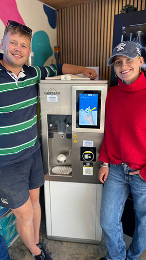 Two people by a soft serve machine