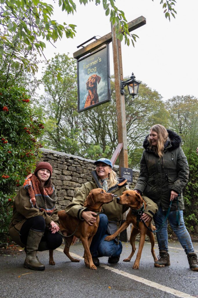 Farmer's Dog pub sign with "lookalike" dog competitors and their owners