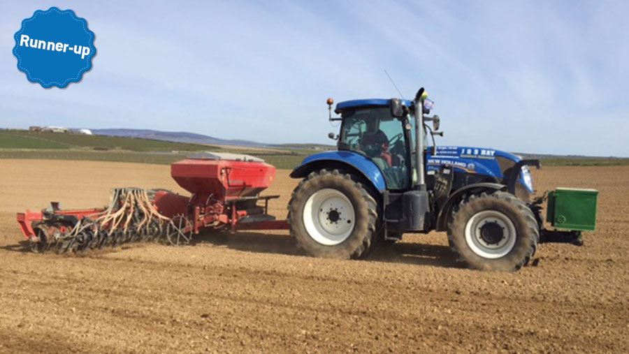 A tractor pulls a drill in a field