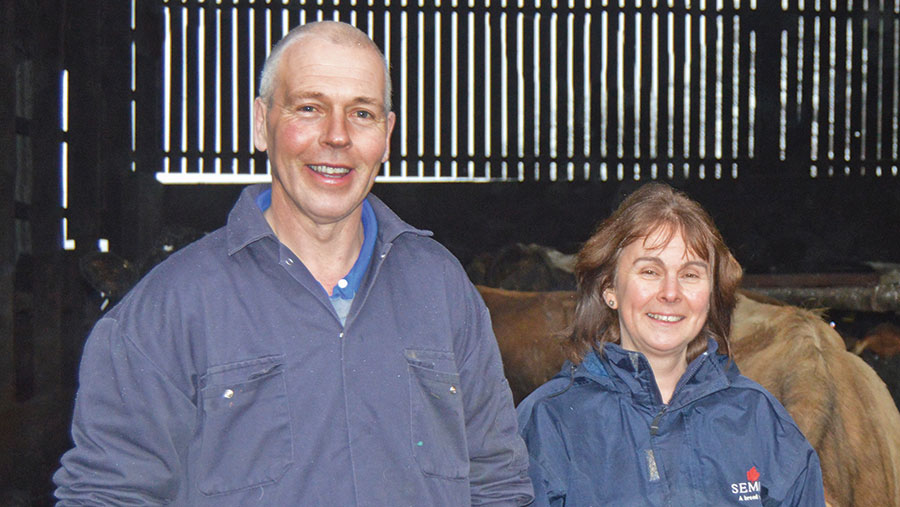 Richard and Heather Gibson stand in a cow shed