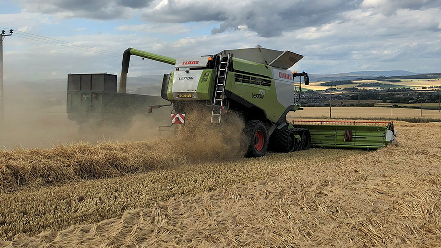 A combine harvester works through a field of winter wheat