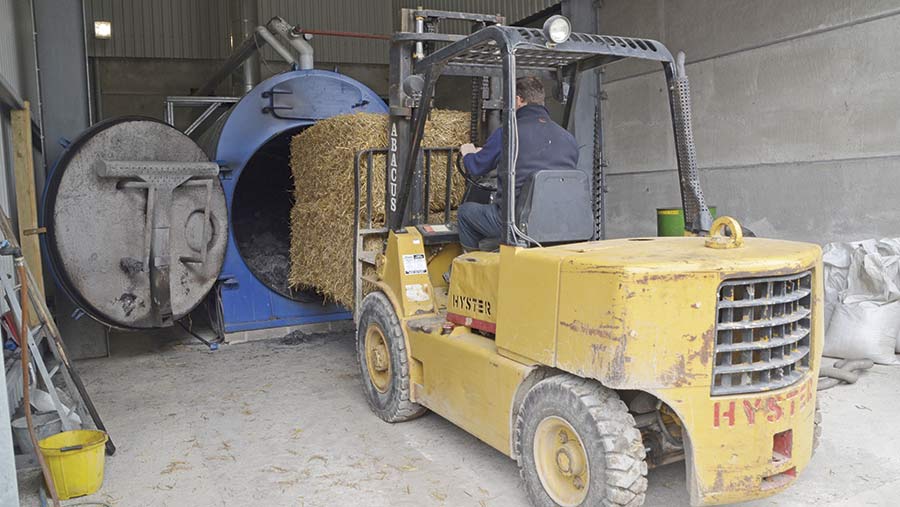 Loading bales into the grain dryer. © Nick Fone