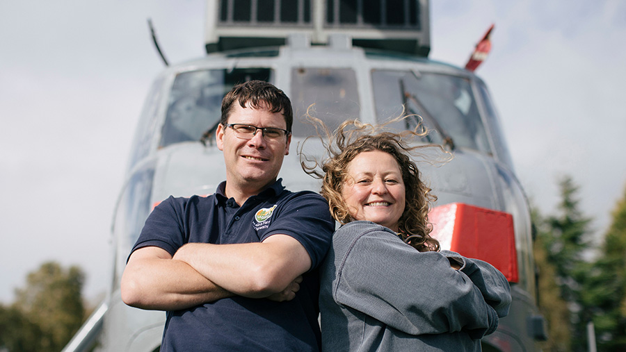 Martyn and Louise Steedman standing in front of Sea King helicopter