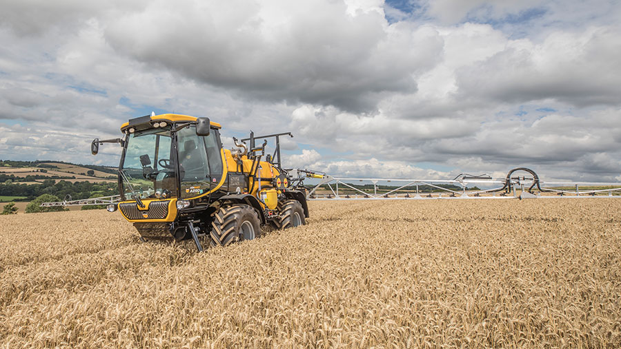 A yellow and black A280 Agribuggy works in a field with its booms unfurled
