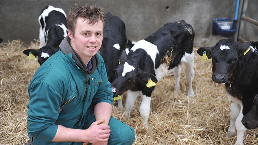 Andrew Rees crouches in a calf pen