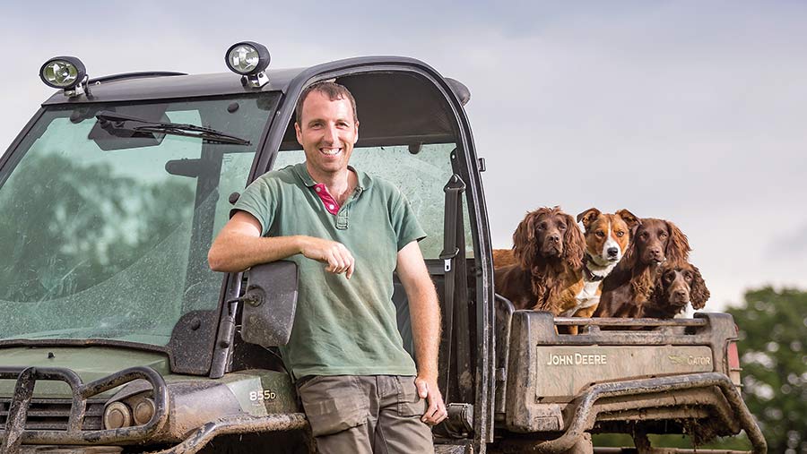 Dylan Williams standing in front of his ATV with farm dogs