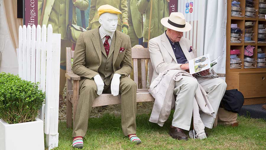 Man sitting next to a mannequin at the Game Fair