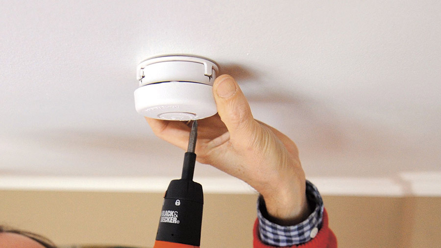 Smoke alarm being fitted