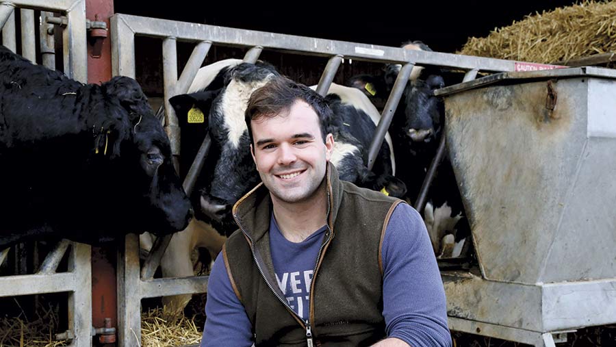 Jack Stilwell in front of dairy cows in a shed