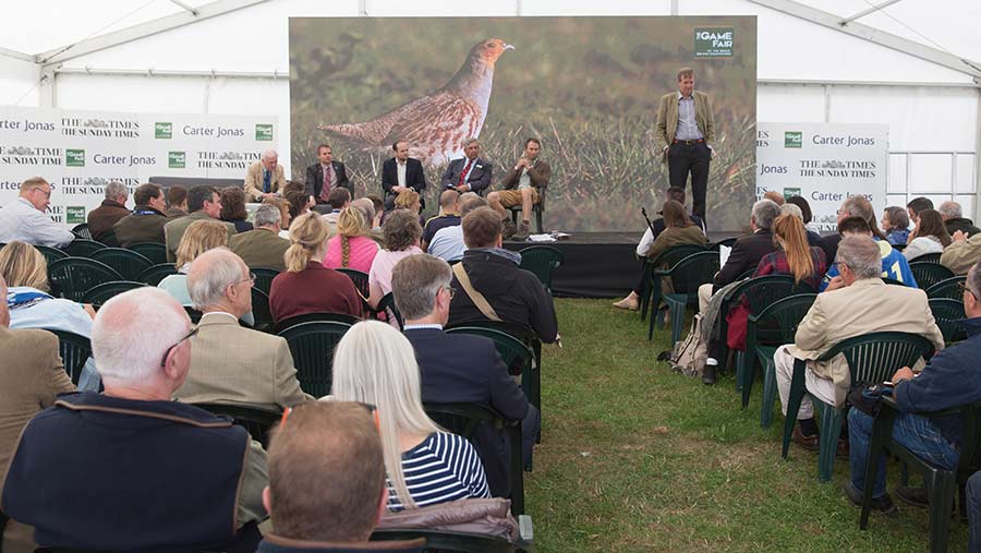 People in tent discussing grouse at Game Fair