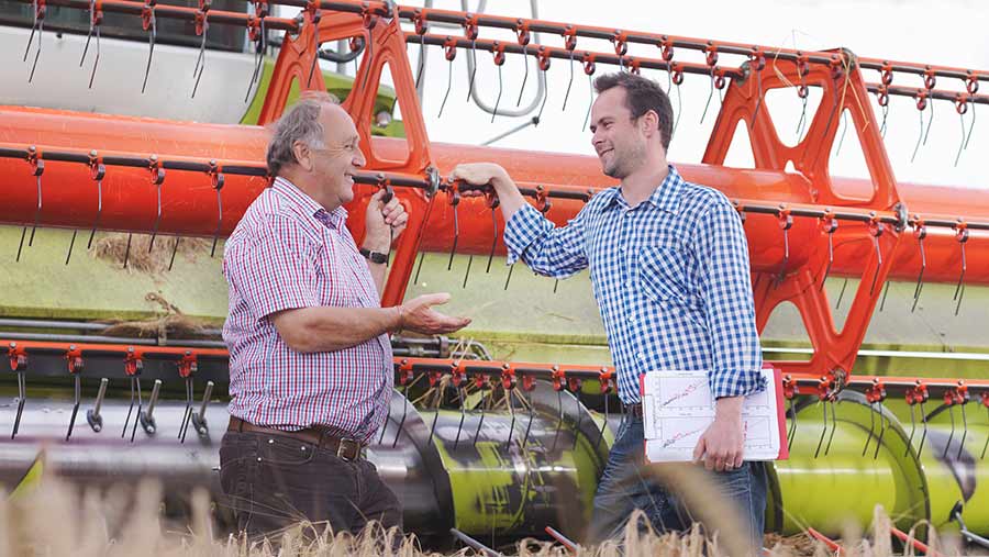 Farmers having a conversation in front of a combine harvester