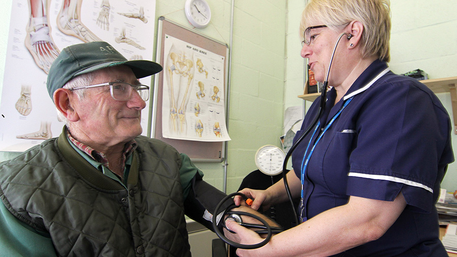 Farmer Frank Lomas has his blood pressure taken by nurse Susan Warren