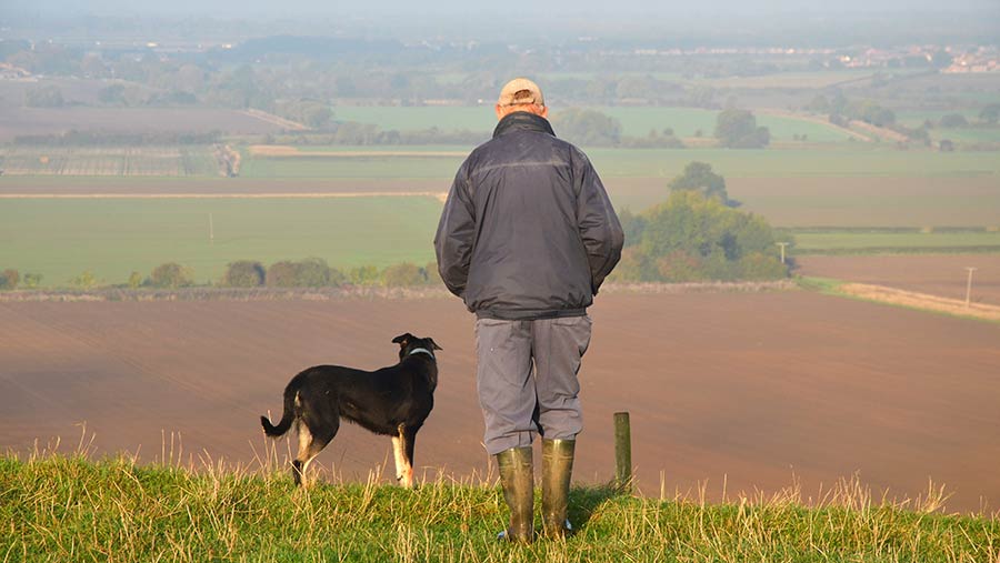 Man and dog standing field