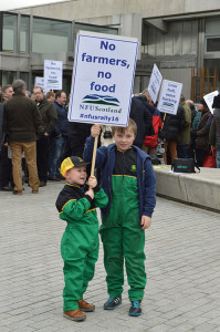 Billy and Jack Beaton hold a banner saying "No farmers, no food" at a protest in Scotland.