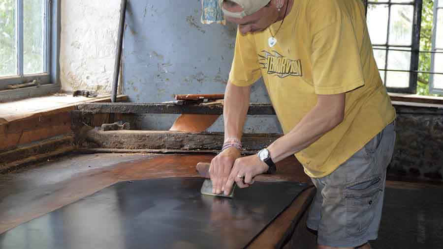 James Tucker polishing a piece of leather