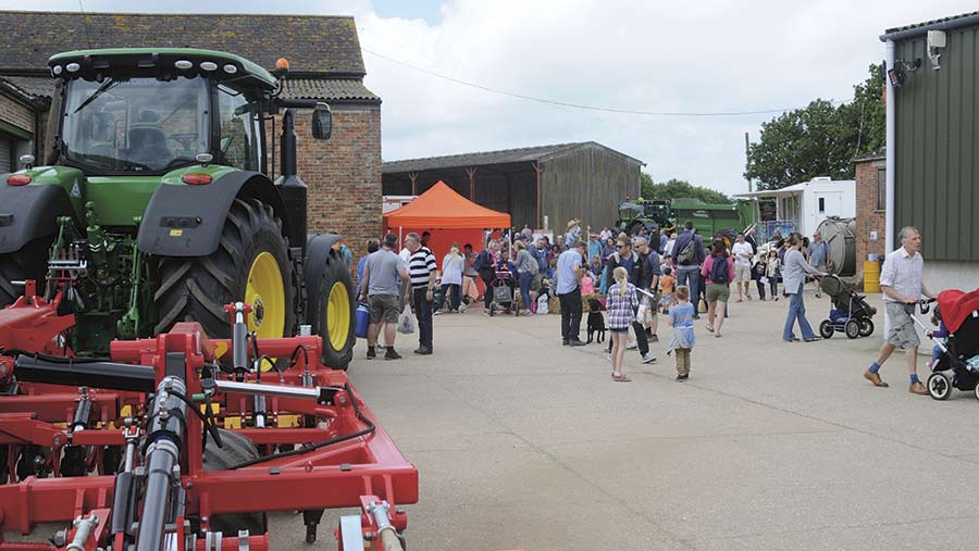 Visitors stand in a farmyard