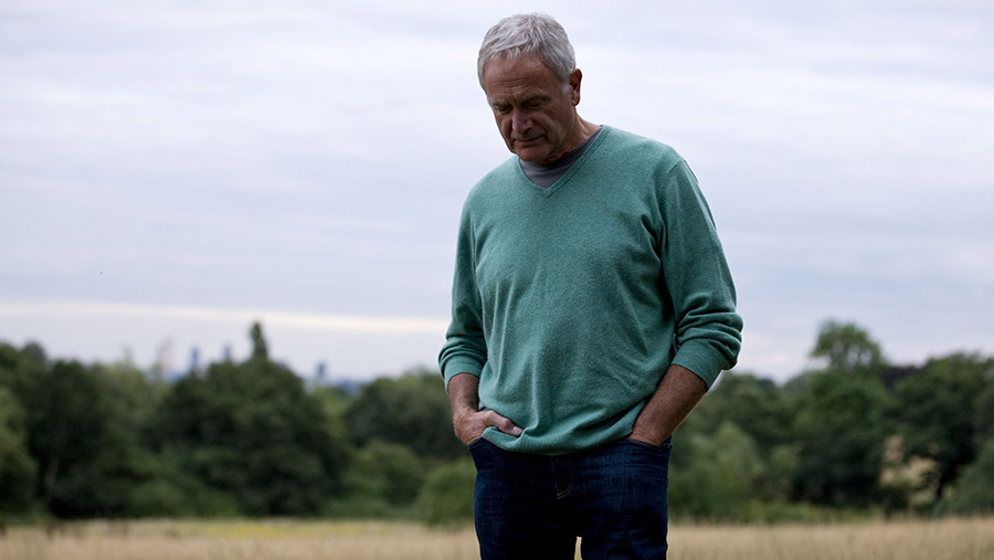 Sad farmer standing in a field