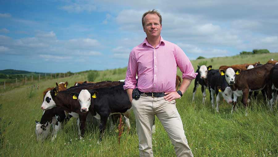 Geoff Sayers in a field with dairy cows