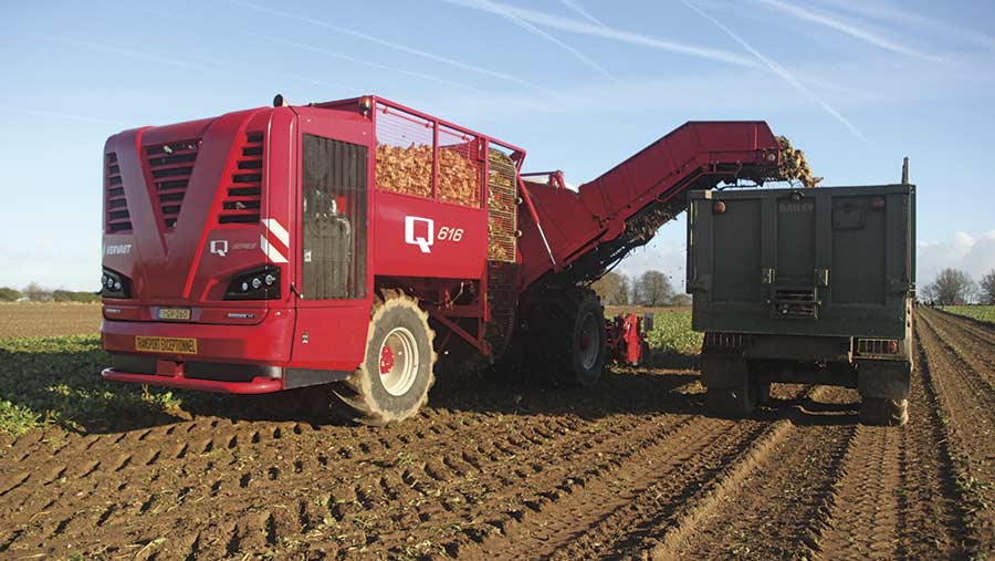 A Vervaet beet harvester unloads beet into a truck as it travels through a field