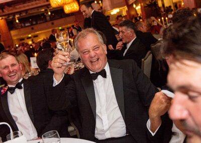 Awards guest raising a glass from his table