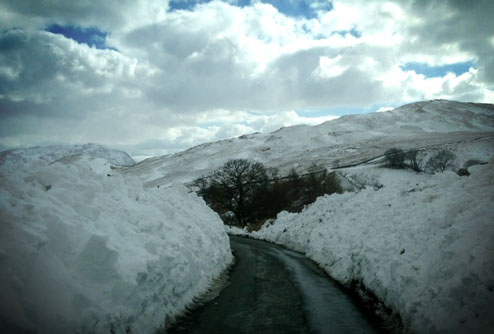 Snowbanks tower over each side of the road