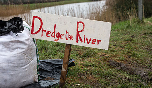 A sign reading Dredge the river
